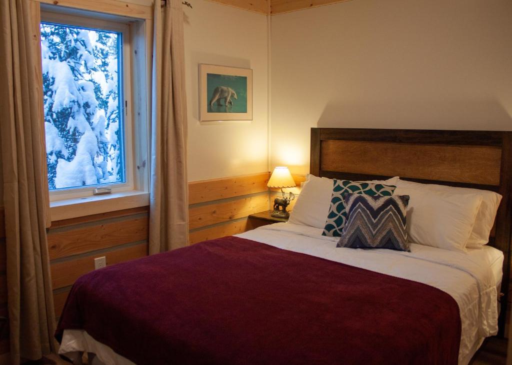 ein Schlafzimmer mit einem großen Bett und einem Fenster in der Unterkunft Denali Wild Stay - Moose Cabin, Free Wifi, 2 private bedrooms, sleep 6 in Healy