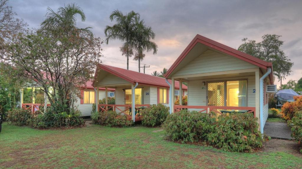 ein Haus mit einem roten Dach und einem Hof in der Unterkunft Flying Fish Point Tourist Park in Innisfail