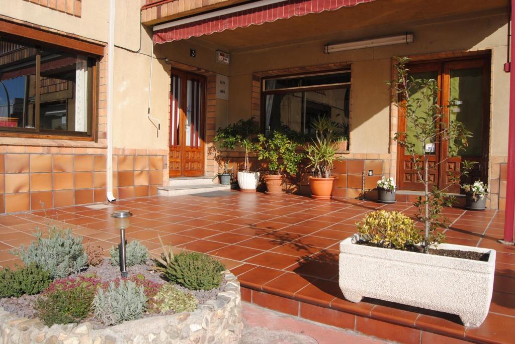 un patio con macetas frente a un edificio en Hostal El Mirador en La Lastrilla