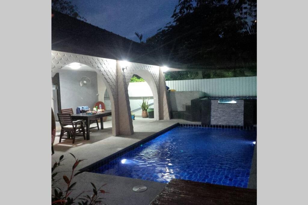 a swimming pool in a backyard at night at Villa Rosa with Private Pool and Jacuzzi 100m to beach in Pattaya South