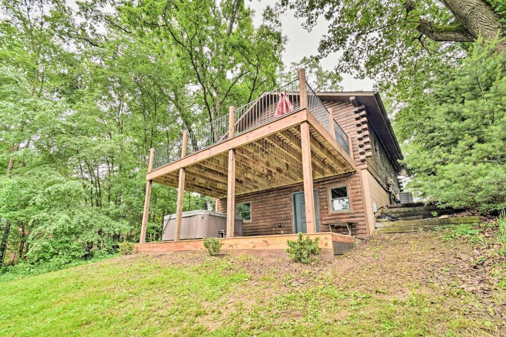 a house with a deck on top of a hill at Cozy Amish Country Cabin on Shipshewana Lake! in Shipshewana
