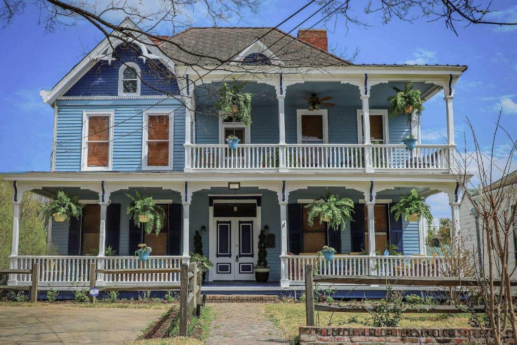 ein altes blaues Haus mit einer weißen Veranda in der Unterkunft Vicksburg Home with 3 Porches, Walk to Downtown in Vicksburg