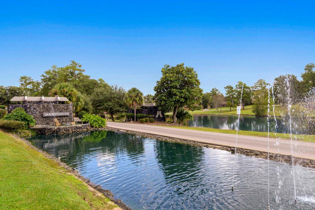 a fountain in the middle of a road next to a pond at Golfer's Getaway! Modern Diamondhead Condo in Diamondhead