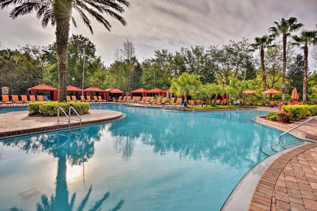 una piscina en un complejo con palmeras en Davenport Condo with Pool Access 10 Mi to Disney, en Kissimmee