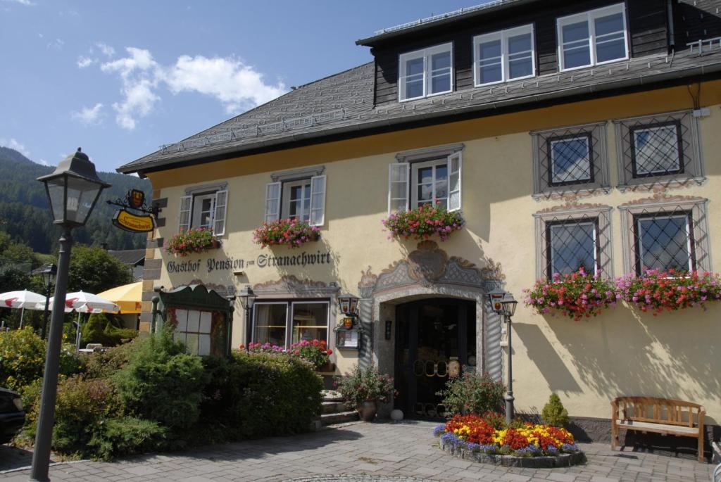 a large yellow building with flowers in front of it at Hotel Gasthof Stranachwirt in Sankt Michael im Lungau