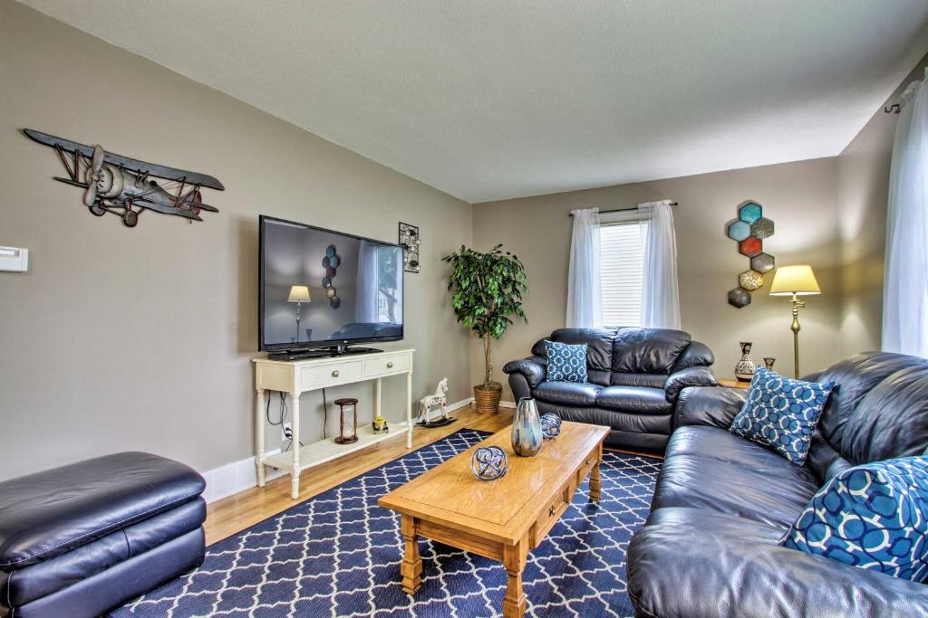 a living room with leather furniture and a flat screen tv at Rochester House with Yard - 5 Minutes to Mayo Clinic in Rochester