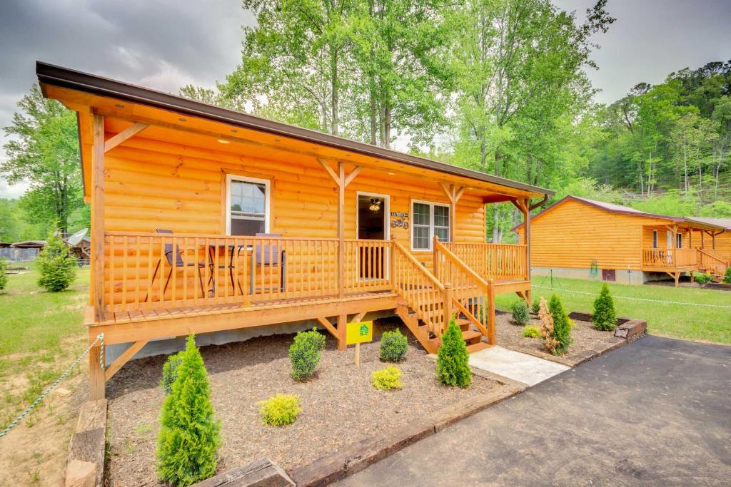 eine Hütte im Wald mit einer großen Terrasse in der Unterkunft Cozy Bryson City Cabin about 6 Mi to Harrahs Casino! in Bryson City