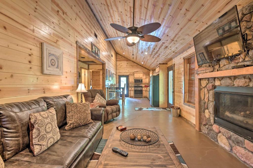 uma sala de estar com um sofá e uma lareira em Cabin with Hot Tub Near Broken Bow Lake and Hiking em Broken Bow