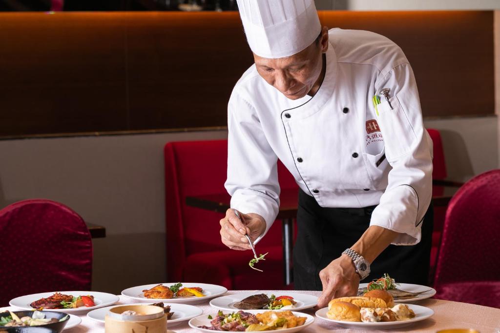a chef preparing food on a table with plates of food at HiONE Holiday Hotel in Shenkeng