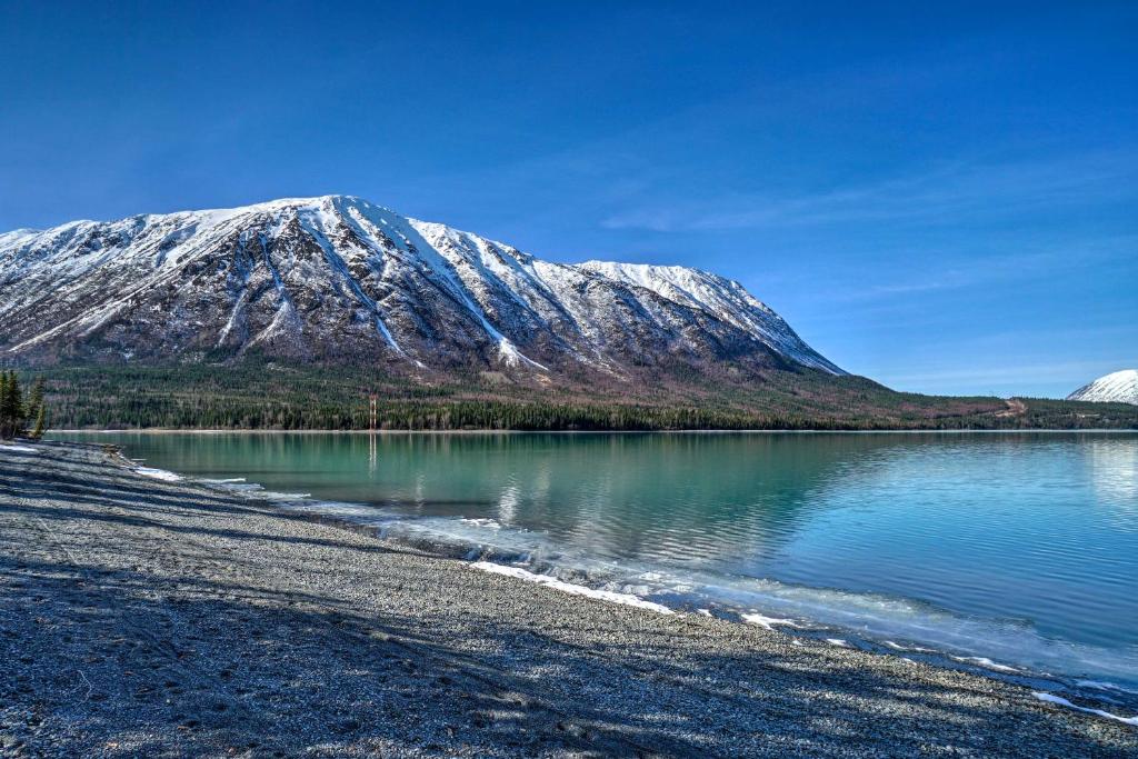 a snow covered mountain sitting next to a body of water at Peaceful Mountain-View Home - Walk to Kenai Lake! in Cooper Landing