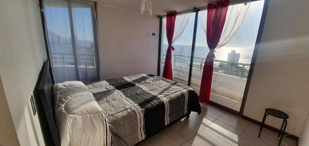 a bedroom with a bed and a large window at departamento NEO vista al mar 2 piezas in Iquique