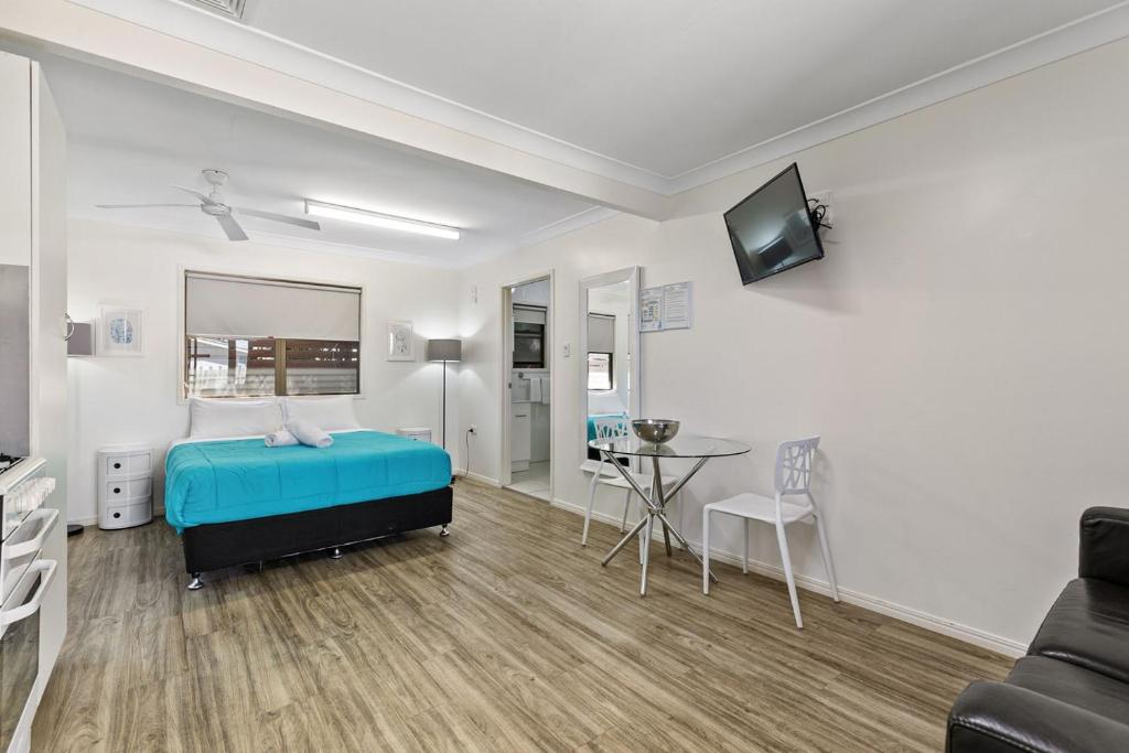 sypialnia z łóżkiem, stołem i kanapą w obiekcie Tasman Holiday Parks - Torquay Palms w mieście Hervey Bay