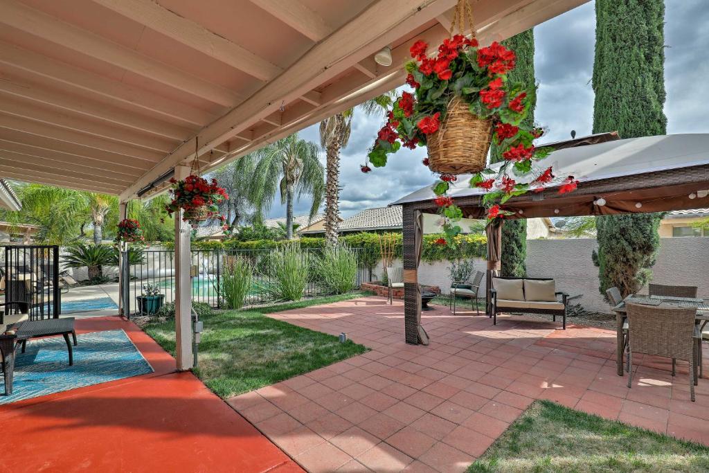 een patio met een tafel, stoelen en bloemen bij Tucson Getaway with Yard, Pool, Hot Tub and Gas Grill! in Tucson