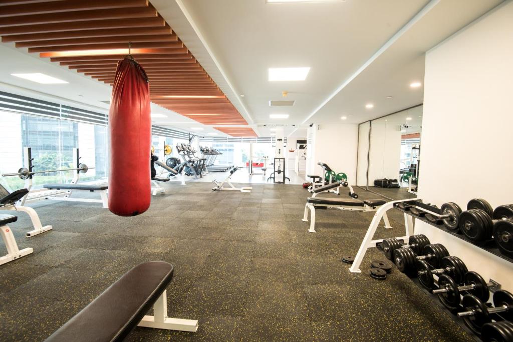 A large gym with a punching bag, free weights and open training space.