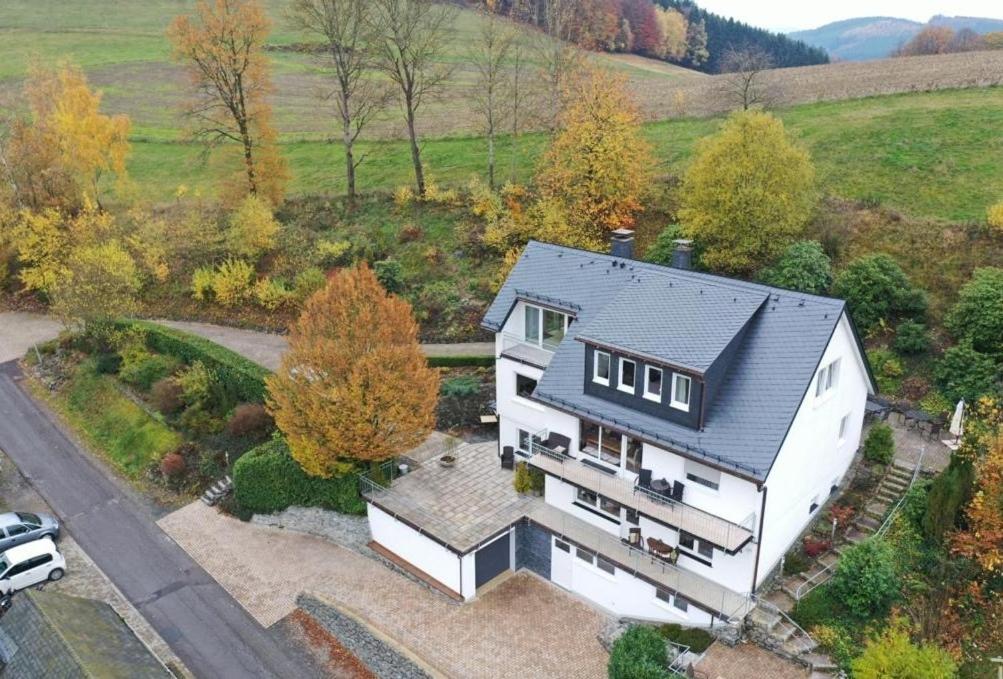 una vista aérea de una casa blanca con techo negro en Auwers Haus komplett zur Alleinnutzung - 3 Wohneinheiten, en Schmallenberg