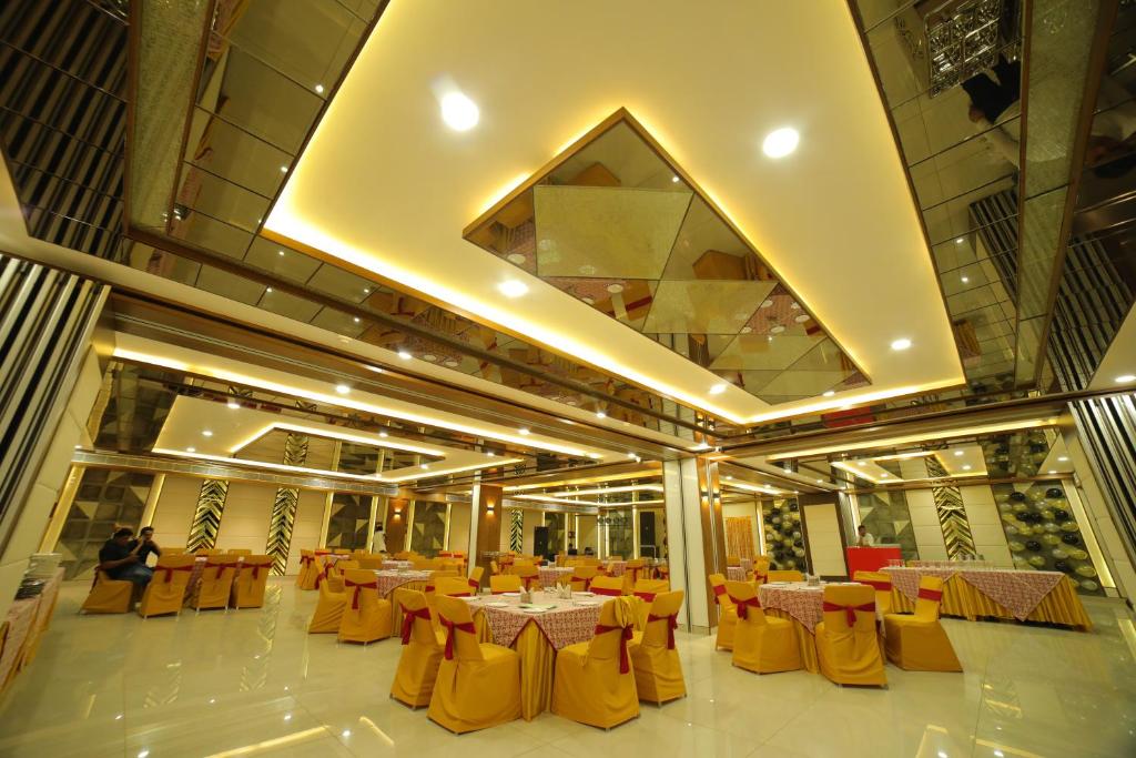 un salón de banquetes con mesas y sillas amarillas en Vijay Vilas Hotel & Convention Hall, en Agra