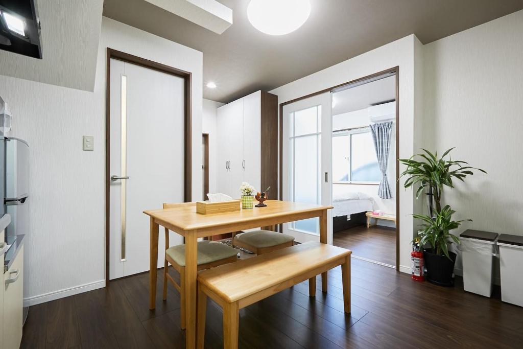 ein Esszimmer mit einem Holztisch, einem Tisch und Stühlen in der Unterkunft Ka's house in Tokio