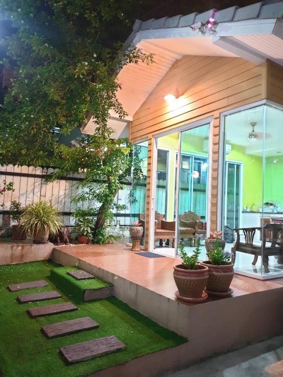 a house with a patio with grass and plants at Papermoon Guesthouse in Bangkok
