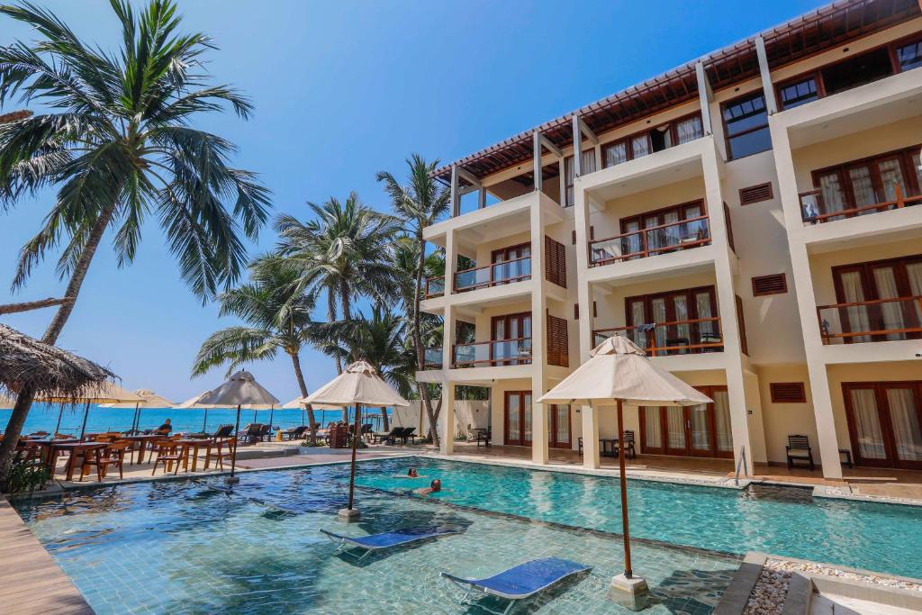 a view of the hotel and the swimming pool at Sapphire Seas Beachfront Hotel in Hikkaduwa