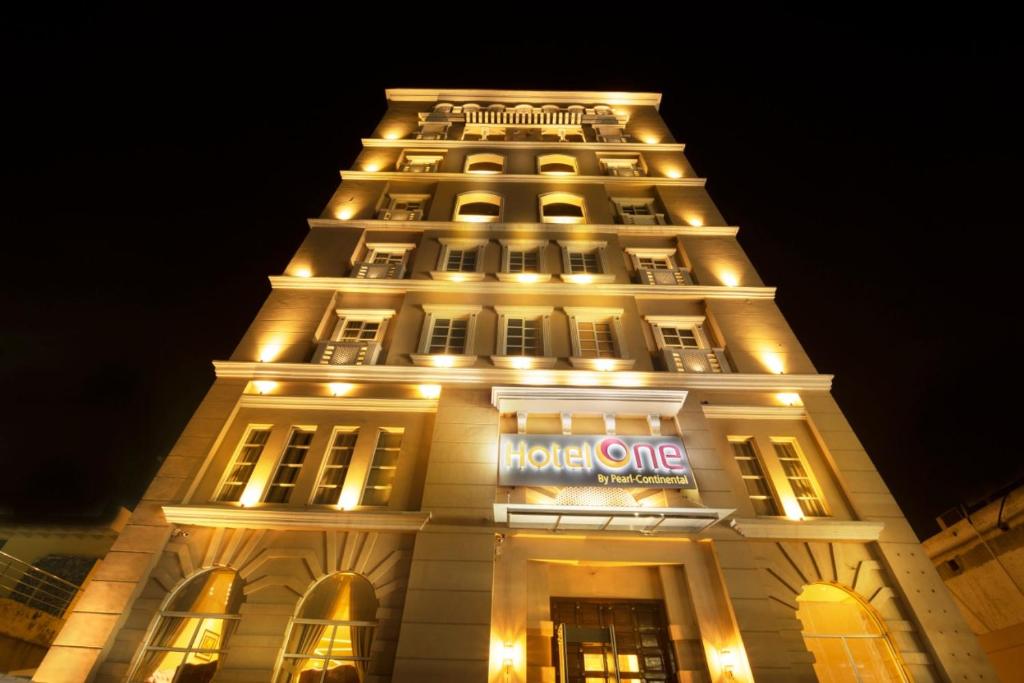 un edificio con un hotel iluminado por la noche en Hotel One Garden Town, Lahore, en Lahore