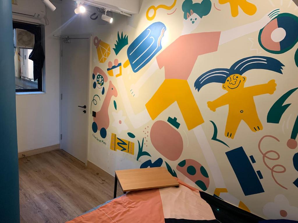 a room with a wall covered in colorful childrens drawings at Wontonmeen in Hong Kong