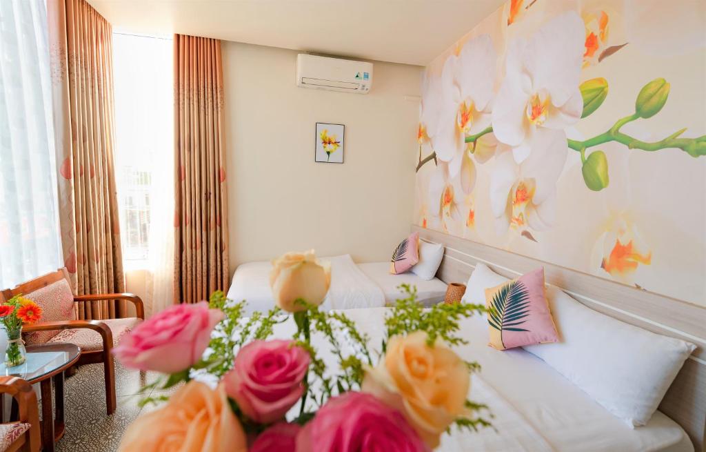 Un dormitorio con una cama con flores. en Flora Hotel Hue en Hue