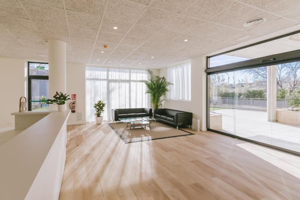 uma sala de estar com um sofá e uma mesa em CIM Aparthotel em Sant Cugat del Vallès