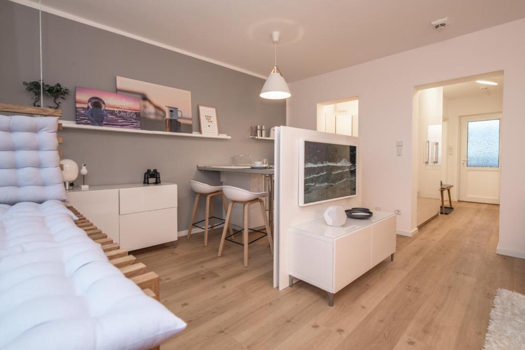 een woonkamer met een bed en een tafel bij Haus Dünenbake, Ferienwohnung Strandpeter Meerblick (Wohnung 47) in Sankt Peter-Ording