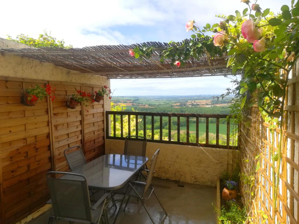 - une table et des chaises sur une terrasse avec vue dans l'établissement Gite des remparts à Lectoure, à Lectoure