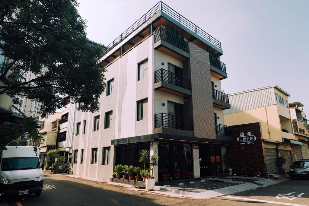 a building on a street with a van parked in front of it at Tianli Hotel in Tainan