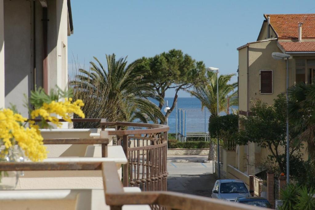 a balcony with a view of the ocean and palm trees at Appartamento Minerva int3 - MyHo Casa in Tortoreto Lido