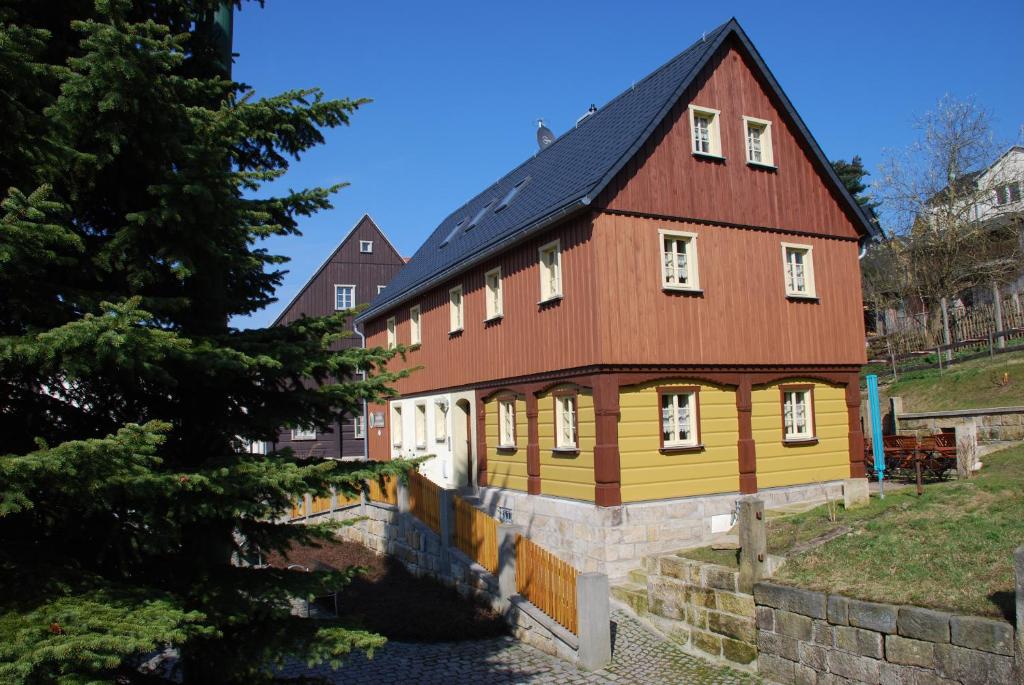 uma grande casa de madeira com um telhado vermelho em FH Am Osterbrunnen em Hinterhermsdorf