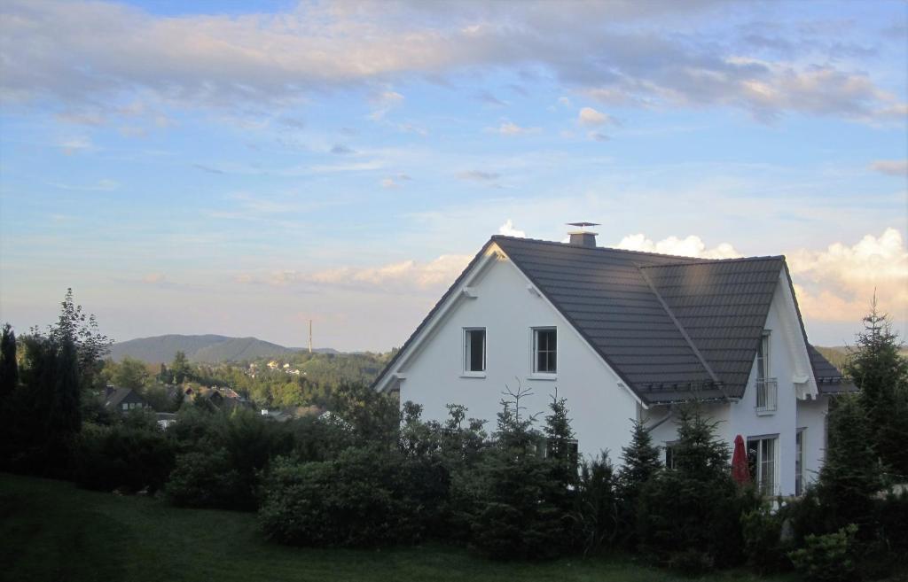 una casa blanca con techo negro en una colina en Schneekäppchen 2, en Winterberg