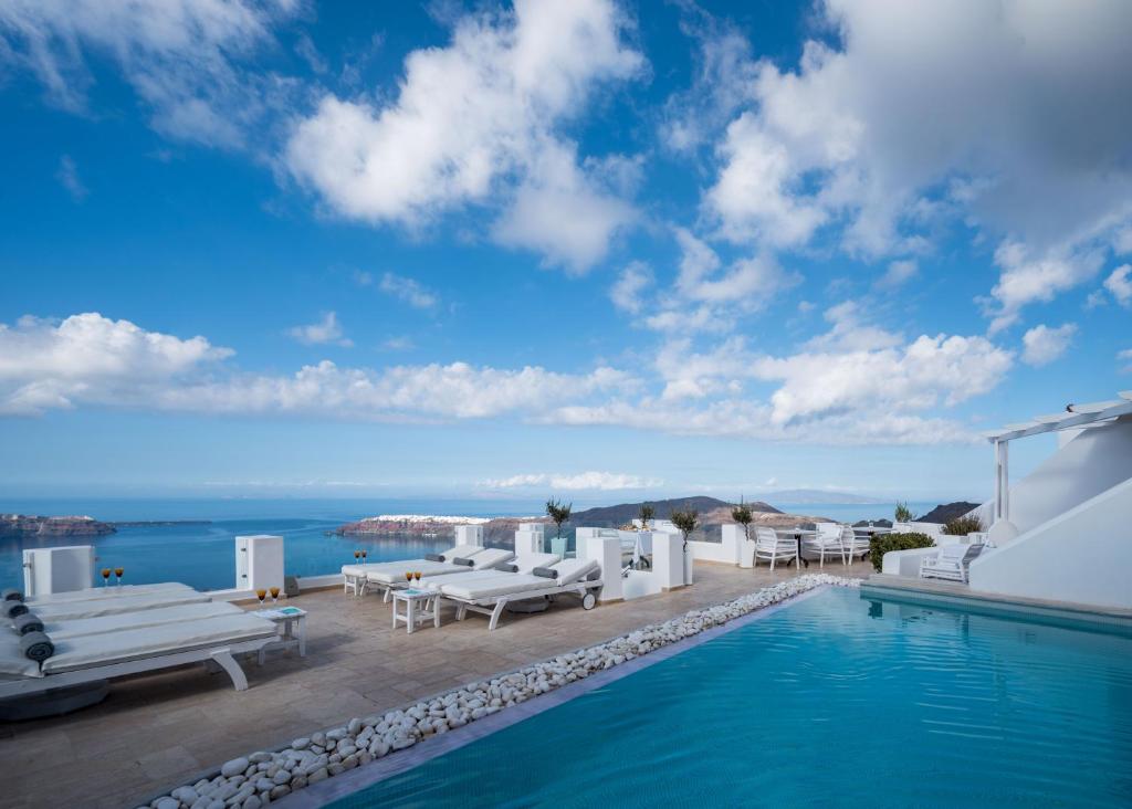 a villa with a swimming pool and a view of the ocean at Above Blue Suites in Imerovigli