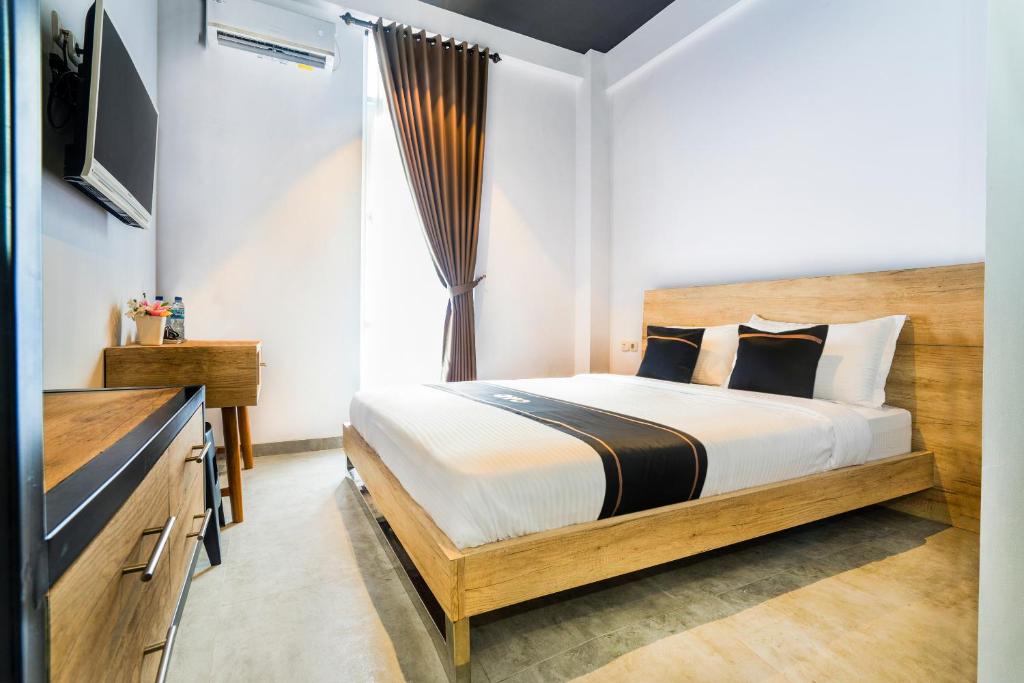 a bedroom with a large bed and a television at Super OYO Collection O 2627 Ratamya Co-living in Yogyakarta