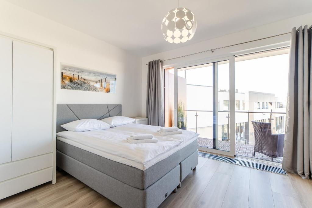 a bedroom with a bed and a large window at Apartamenty Flamingo by Renters in Międzyzdroje