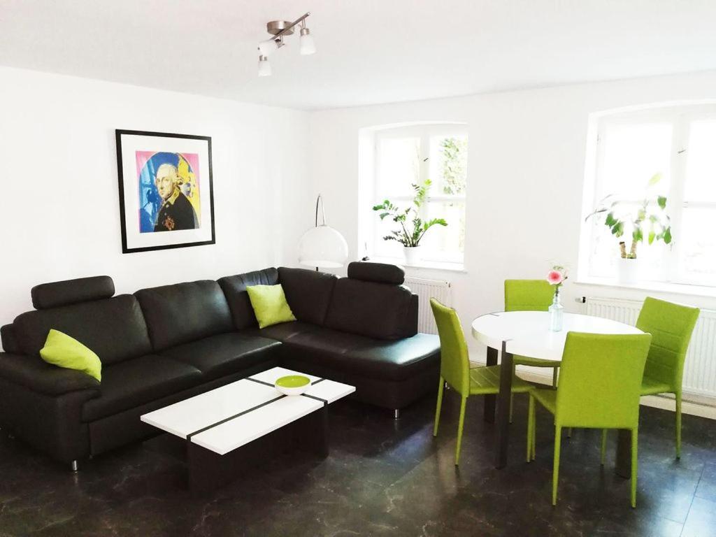 a living room with a black couch and a table at Halbe Treppe in Potsdam