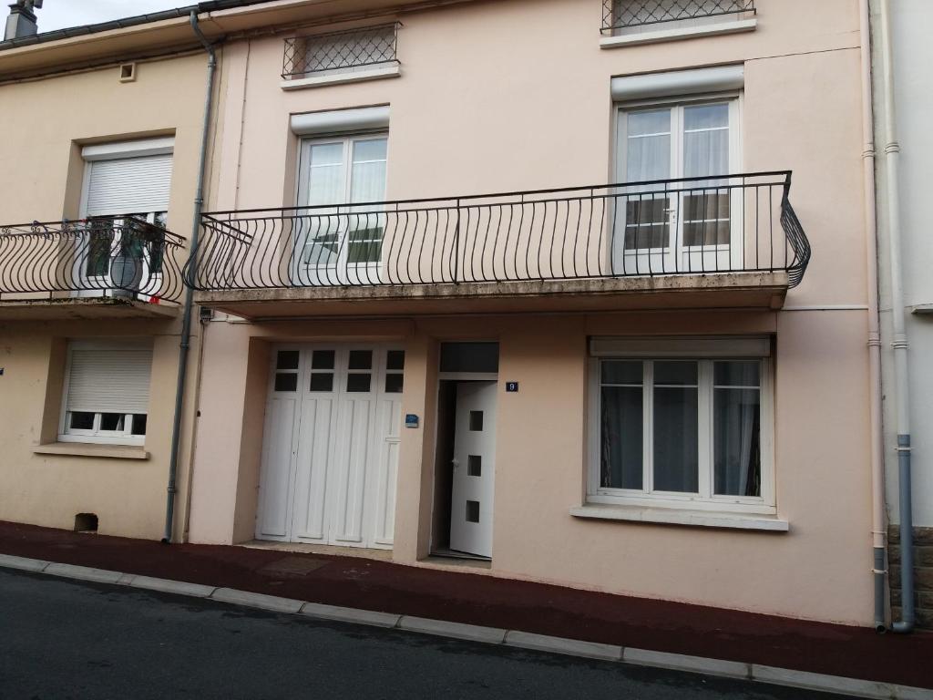 een appartementencomplex met een balkon en een deur bij Gîte "les hortensias" au coeur de Lacaune in Lacaune