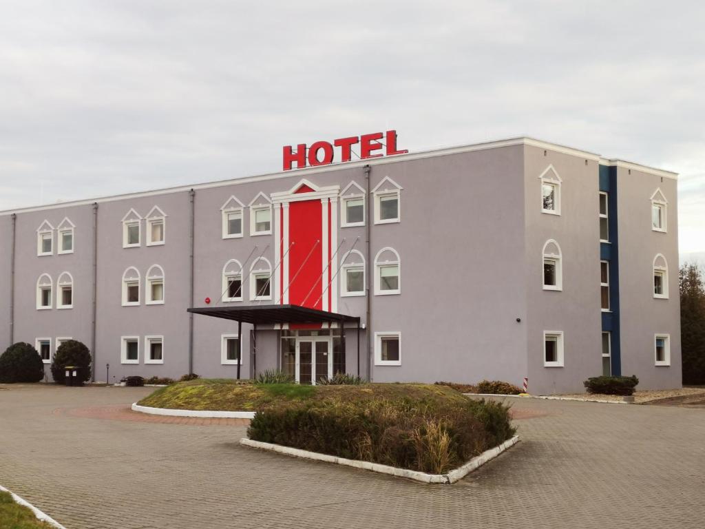 a hotel with a red sign on top of it at Hotel Holidays in Słubice