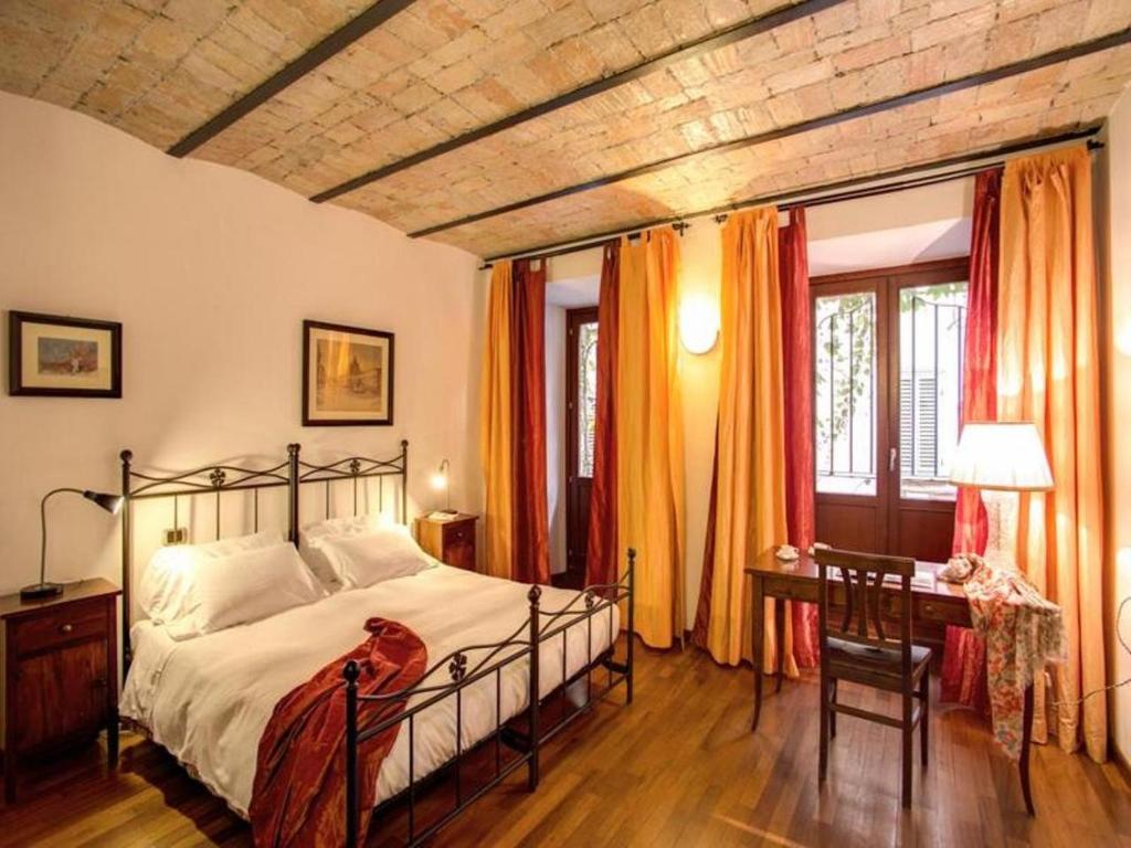 ローマにあるレジデンツァ ドミツィアのベッドルーム1室(ベッド1台、テーブル、窓付)