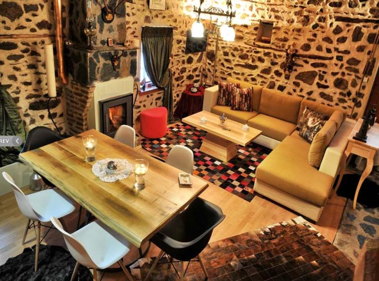 uma sala de estar com uma mesa e um sofá em Villas De Luna em Sidhirokhórion