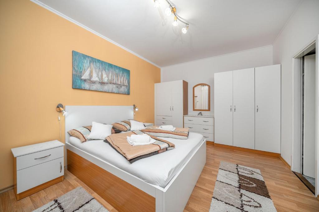 a bedroom with a large white bed in a room at Adria Sun Apartments in Vodice