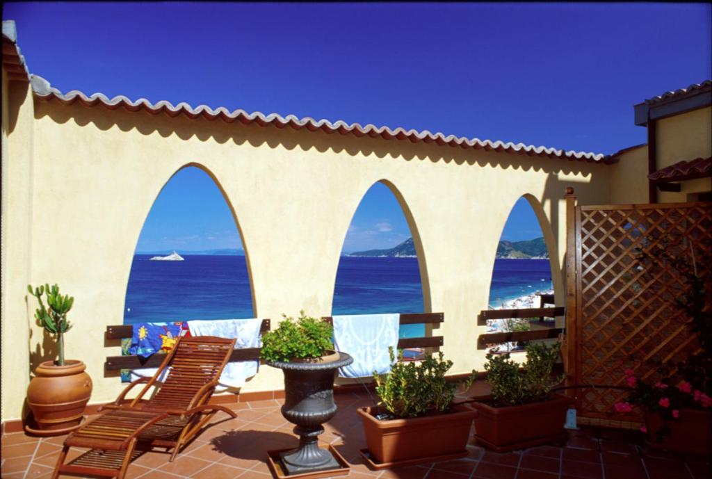 d'une terrasse avec des chaises et une vue sur l'océan. dans l'établissement Le Ghiaie Relax, à Portoferraio