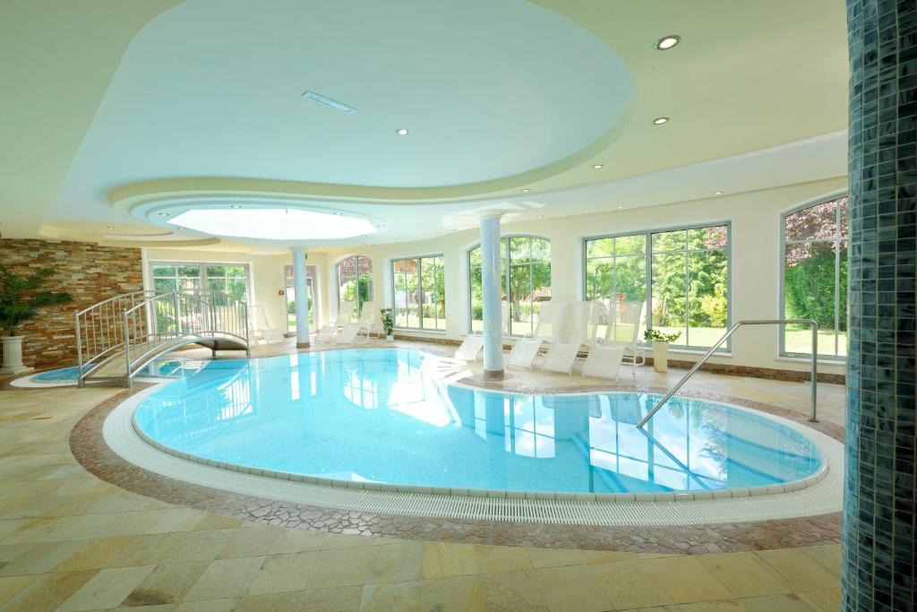 una grande piscina in una casa con soffitto di Hotel Herrschaftstaverne a Haus im Ennstal