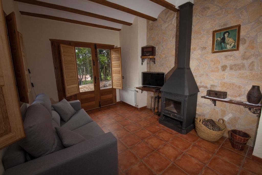 a living room with a couch and a fireplace at Cases dels Gasulla in Chiva de Morella