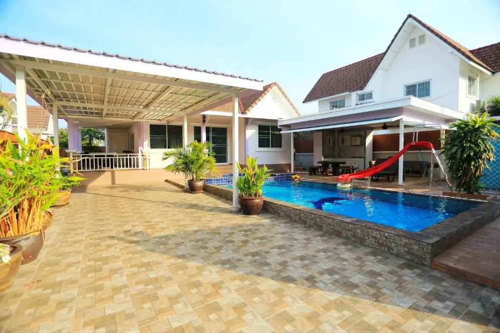 een huis met een zwembad en een speeltuin bij Tropical Hill Pool Villa in Hua Hin