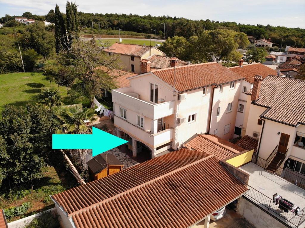 una vista aérea de una casa blanca con una flecha verde en Apartments Sain with garden terrace near the beach en Poreč