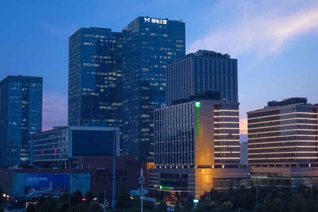 um grupo de edifícios altos em uma cidade à noite em Holiday Inn Express Zhengzhou Zhengdong, an IHG Hotel em Zhengzhou