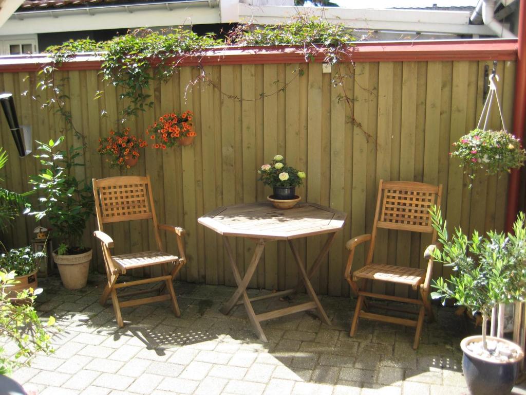 a table and two chairs and a table and a fence at Kerteminde-ferielejlighed in Kerteminde