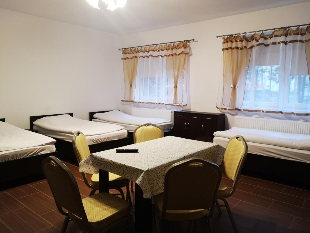 Habitación con camas, mesa y sillas. en Pokoje o wysokim standardzie, en Słupsk